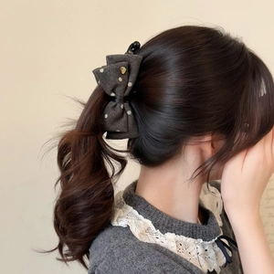 Elegant dark grey polka dot bow hair claw clip for high ponytail styling on brunette hair