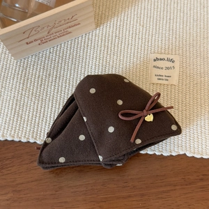 Détail de la pince à cheveux en velours marron à pois blancs avec pendentif cœur doré