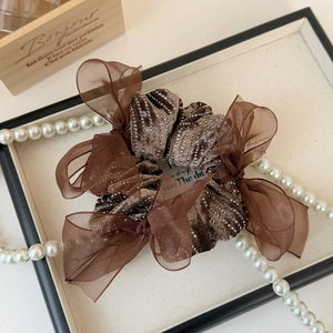 Detailed macro view of vintage brown velvet bow scrunchie with rhinestones and organza