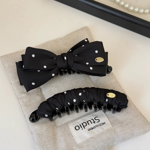 Polka dot bow hair clip and banana clip set on a minimalist linen pouch for women