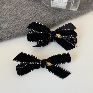 Elegant black velvet bow hair clip with white stitching and golden metal charm detail
