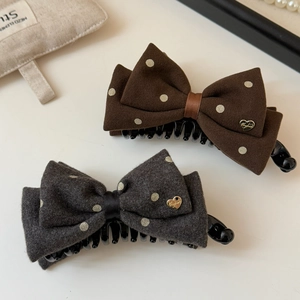Set of two elegant polka dot bow hair clips with gold heart metal accents in dark tones