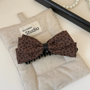Detail view of the leopard print fabric bow hair clip with black center ribbon detail