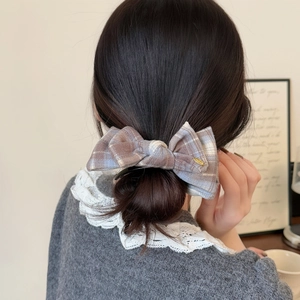 Brown and light blue plaid bow hair clip shown on back of head for a retro sweet look