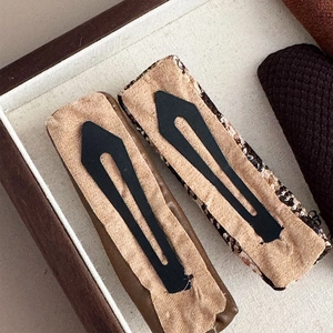 Brown plaid hair clips with matte black metal spring clasps shown from a back view