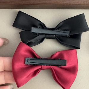 Detail of the black metal alligator clip on the back of the satin bow hair clip