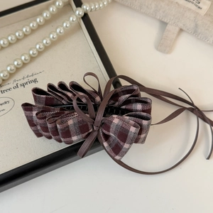 Detail showing vintage plaid fabric bow banana clip with long ribbon and black plastic teeth