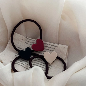 Vue macro détaillée d'un lot de 3 chouchous élastiques cœurs en rouge, noir et beige