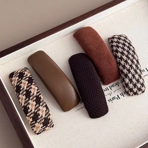 Five-piece vintage plaid hair clip set in brown tones on linen background