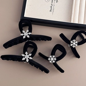 Detail of black velvet hair claws with sparkling rhinestone snowflake designs