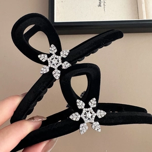 Elegant black velvet claw clip with rhinestone snowflake decor for winter hair styling