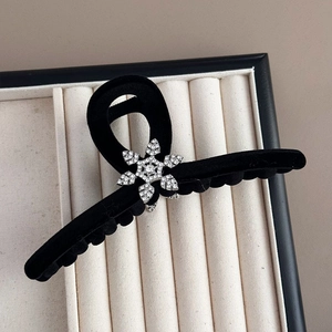 Detail of black velvet hair claw with sparkling rhinestone snowflake ornament