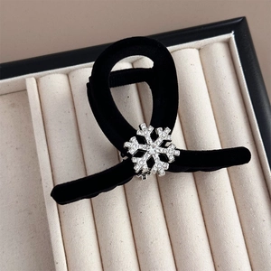 Close-up of elegant black velvet hair claw clip featuring a sparkling rhinestone snowflake