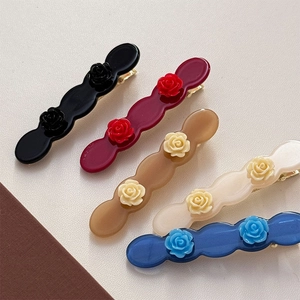 Detailed close-up of wavy resin hair clips with elegant 3D acetate rose flower designs