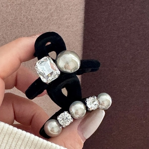 Detail of black velvet hair clip with rectangle crystal and silver pearls accent