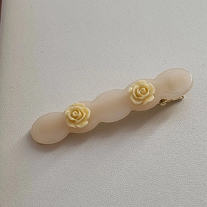 Close-up of acetic acid rose flower hair clip with elegant golden metal fastener back
