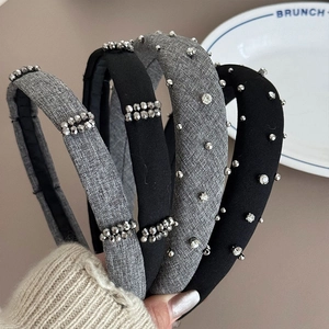 Detail of grey and black fabric headbands with intricate silver rhinestone beadwork