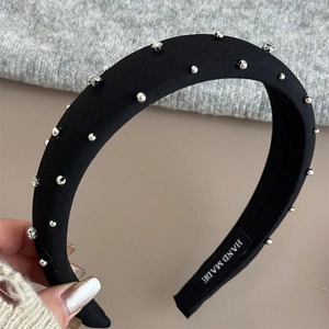 Detail of a padded black headband with silver metal beads and sparkling rhinestones