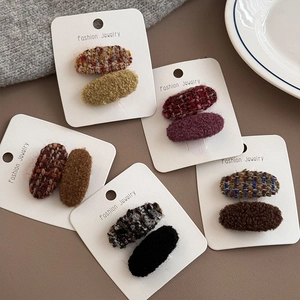 Detaillierte Ansicht ovaler Tweed- und Plüsch-Haarspangen-Sets auf Karten für den Winter