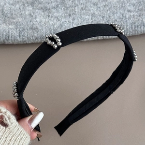 Detail of black fabric headband with faceted silver metallic beads for a luxury look