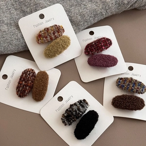 Detail von herbstlichen Tweed- und Plüsch-Haarspangen in verschiedenen Farben