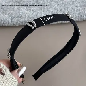 Close-up of black fabric headband featuring 1.5cm width and silver metallic bead details