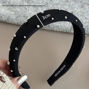 Detail of a 3cm wide black padded headband with sparkling silver rhinestones and handmade tag