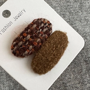 Detail von Wollstoff und Plüsch-Haarspangen auf einer weißen Schmuck-Displaykarte