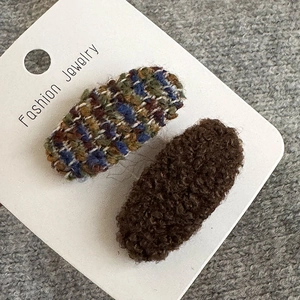 Detail von karierten gewebten und braunen Plüsch-Oval-BB-Clips auf Display-Karte