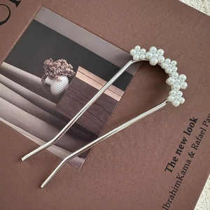 Detailed close-up of U-shaped hair pin with elegant white faux pearl flower decoration