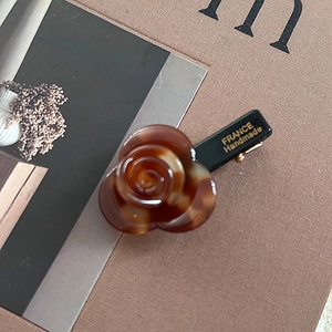 Detailed macro view of an elegant acetate rose hair clip with France Handmade engraving