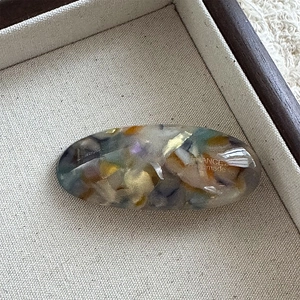 Detailed macro view of acetate hair clip with gold flakes and France handmade engraving
