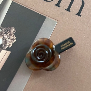 Close-up of handmade acetate hair clip featuring a brown tortoiseshell rose flower design