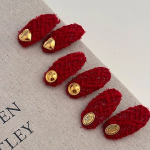 Set of 6 red tweed hair clips with golden heart and bead accents on a linen background