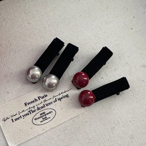 Detailed view of four black velvet hair clips featuring silver and wine red bead accents
