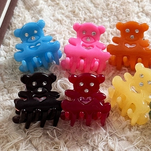 Vue détaillée de six mini pinces à cheveux ours colorées avec strass sur fond peluche