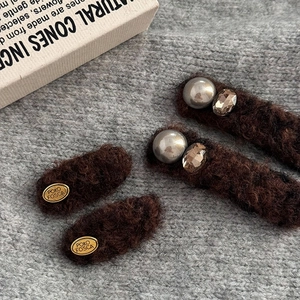 Vintage coffee plush hair clip set with pearls and gold labels on knit background