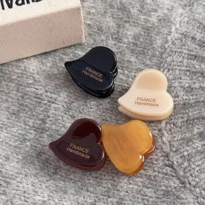 Set di quattro mollette a cuore in acetato nei colori nero, crema, marrone e giallo ambra