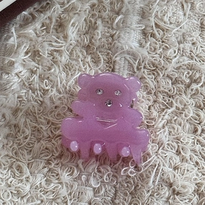 Détail d'une pince à cheveux ours en résine rose avec strass et fini nacré