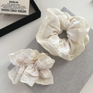 Detail of vintage beige lace hair scrunchies with floral embroidery on soft fabric