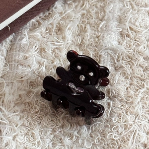 Détail macro d'une mini pince à cheveux ours marron avec des yeux en strass brillants