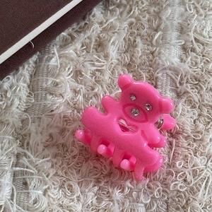 Gros plan sur la pince à cheveux ours rose avec strass sur tissu doux en peluche