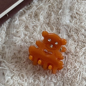 Détail de la pince à cheveux ours en résine ambre avec strass et cœur évidé