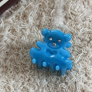 Détail d'une pince à cheveux ours bleu avec cœur évidé et accents en strass brillants