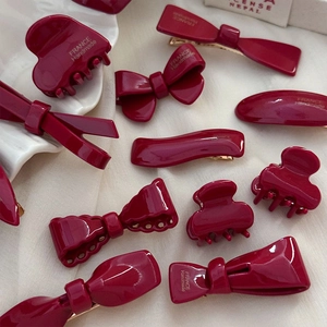 Barrettes et nœuds rouge vin faits main avec finition brillante sur tissu de lin blanc