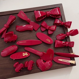 Barrettes à cheveux vintage rouge vin et accessoires en résine brillante sur plateau bois