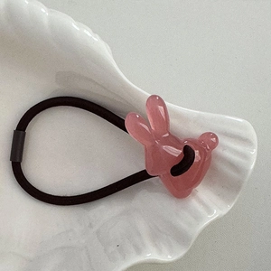 Detailansicht des rosa Hasenschmucks auf dem schwarzen, hochelastischen Haargummi