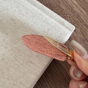 Détail de la pince à cheveux à paillettes roses avec clip crocodile en métal doré