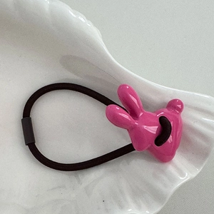 Nahaufnahme von rosa 3D-Hasenhaargummi mit glänzender Textur auf weißem Dekoteller