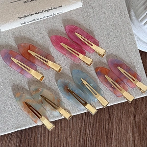 Set of 10 marble acetate hair clips in assorted colors on a linen background